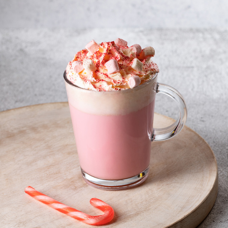 Pink hot chocolate drink with candy cane topping